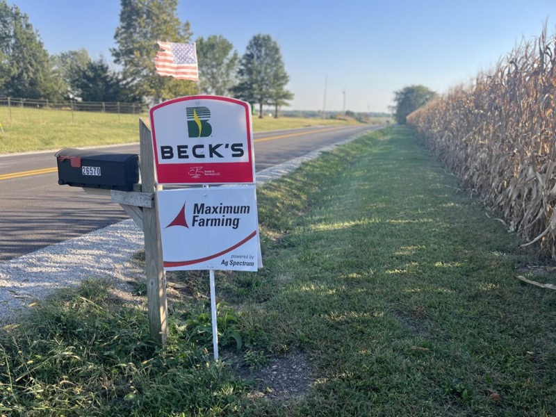 Beck’s and Maximum Farming signs by a mailbox along a country road