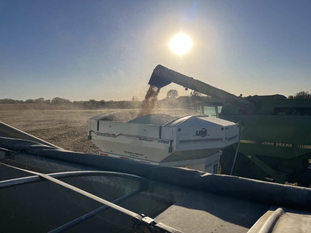 A combine unloading grain into a grain cart at harvest