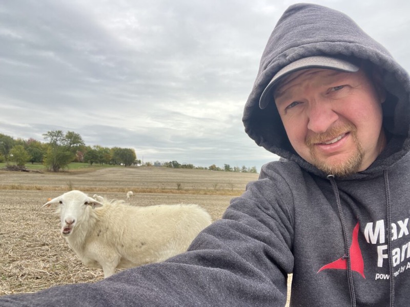 Cory Robinson taking a selfie with a sheep in a field