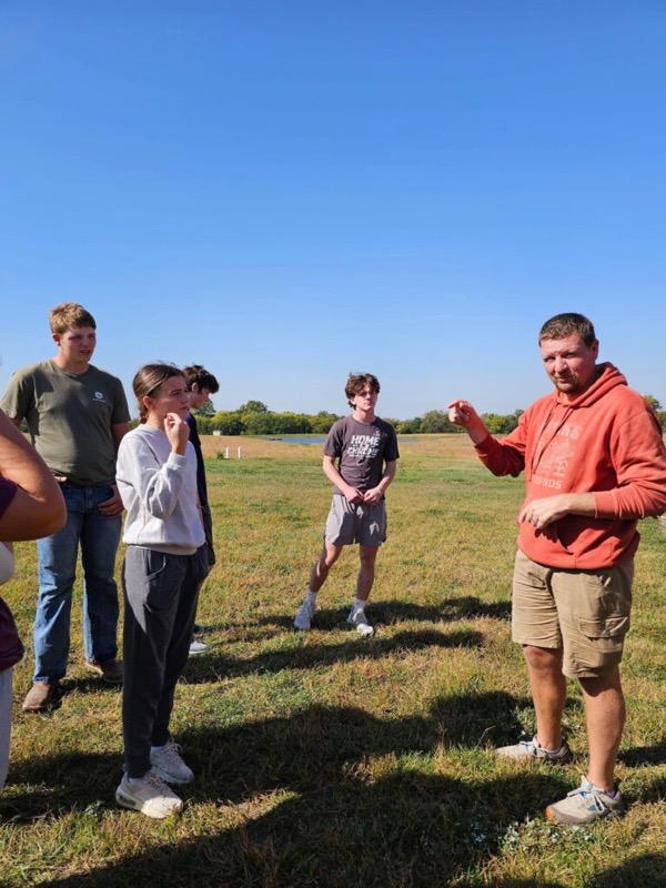 Cory Robinson talking with visitors in a field