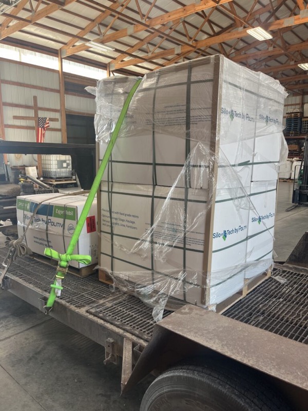 Pallets of farm supplies loaded on a trailer in the warehouse
