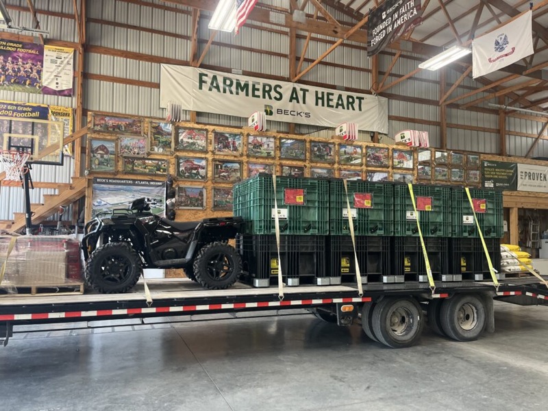 Seed boxes and an ATV on a trailer in the warehouse