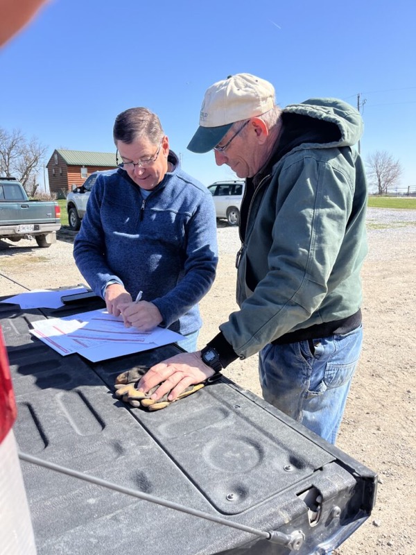 Going over paperwork with a farmer on a truck tailgate